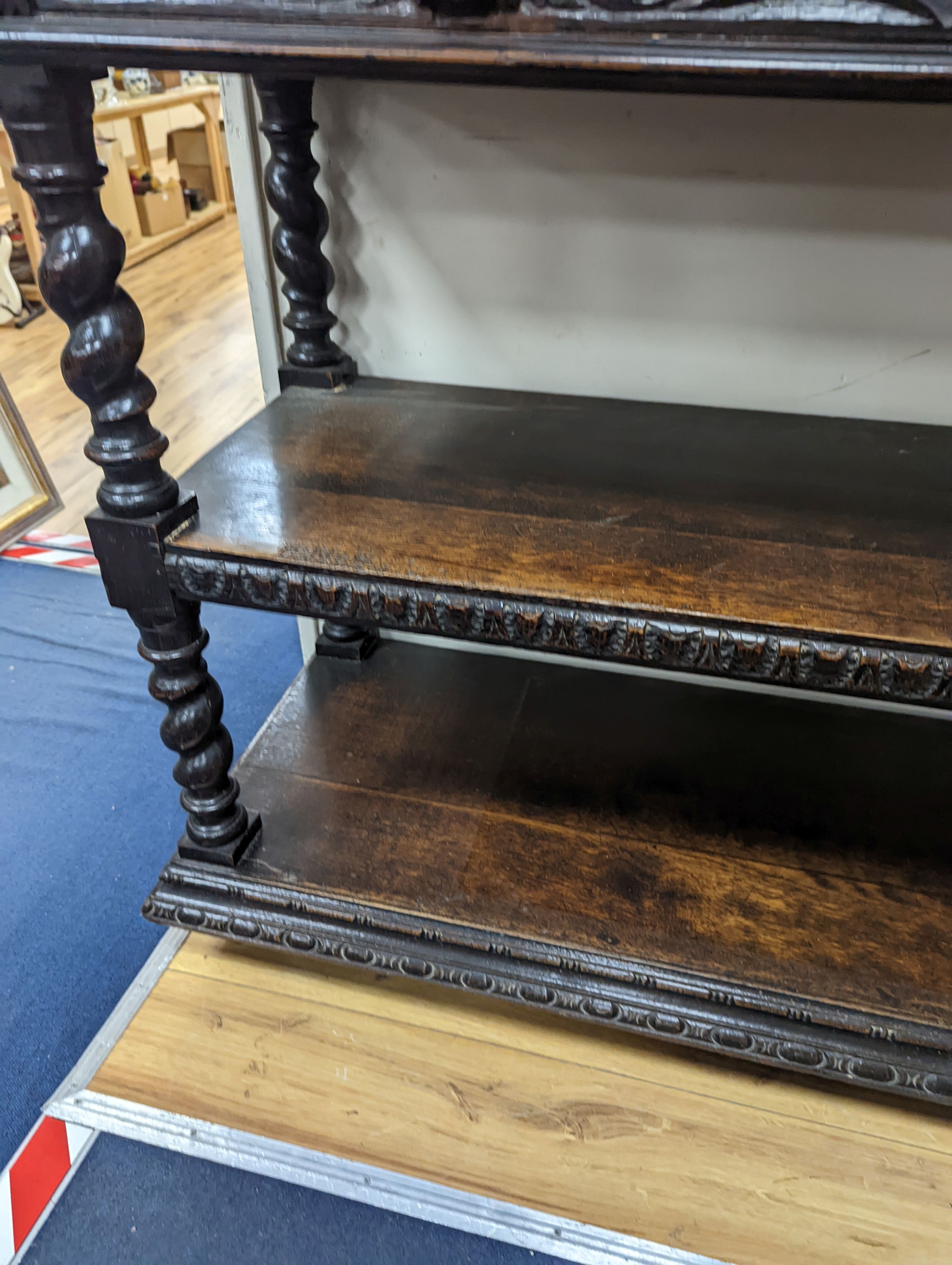 A 19th century Flemish carved oak three tier buffet, length 121cm, depth 46cm, height 98cm